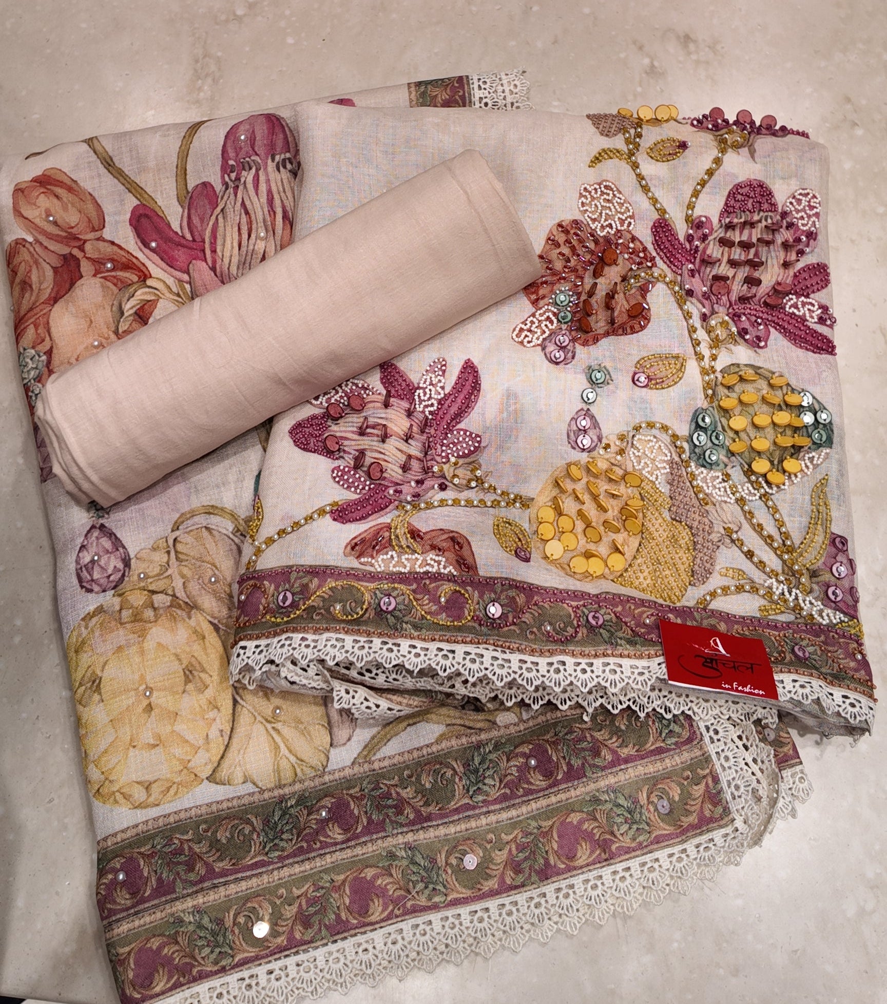Decorative fabric with floral patterns and lace on a beige surface